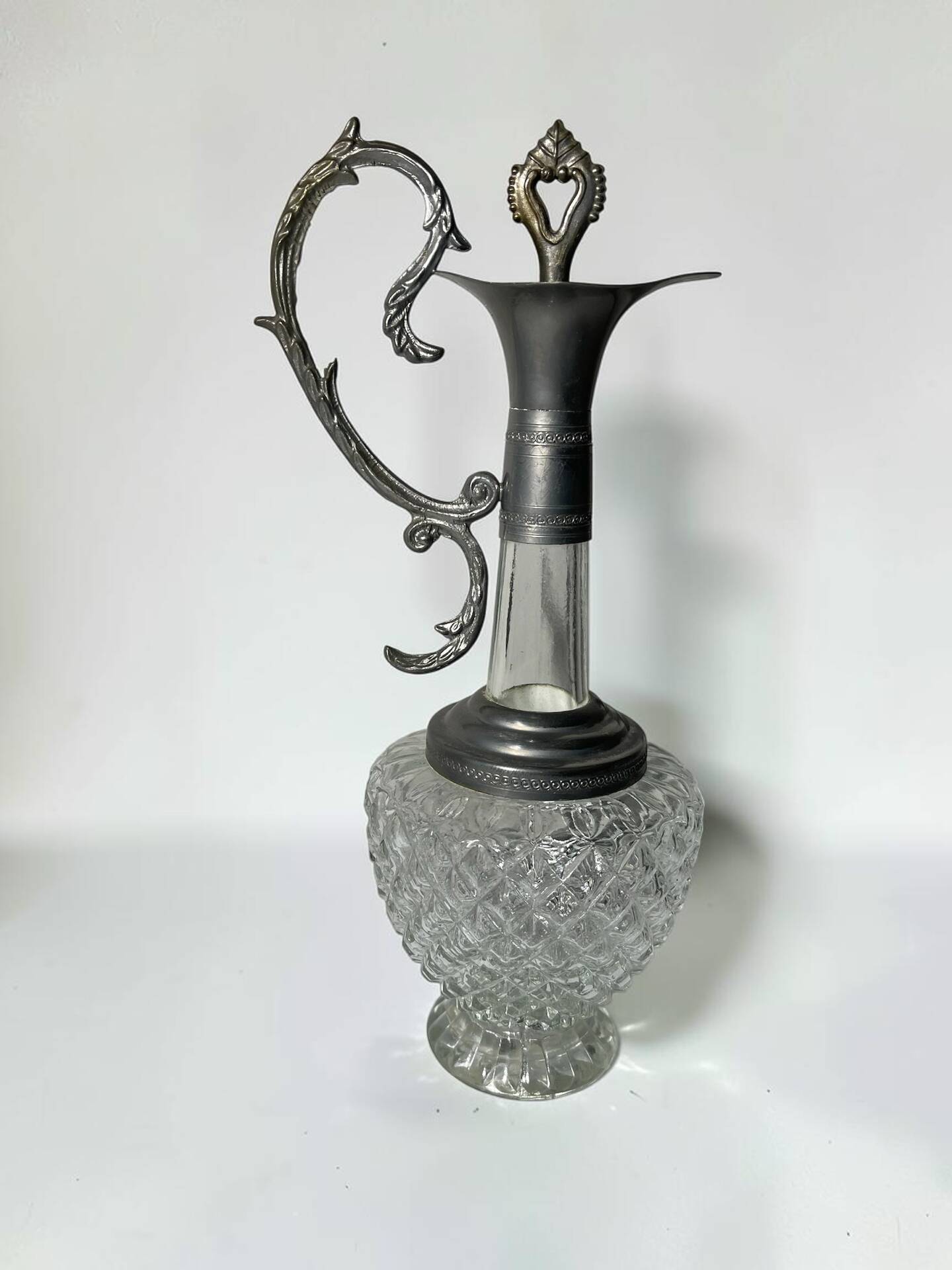 Vintage glass decanter with cut design and silver-plated metal, stopper included.