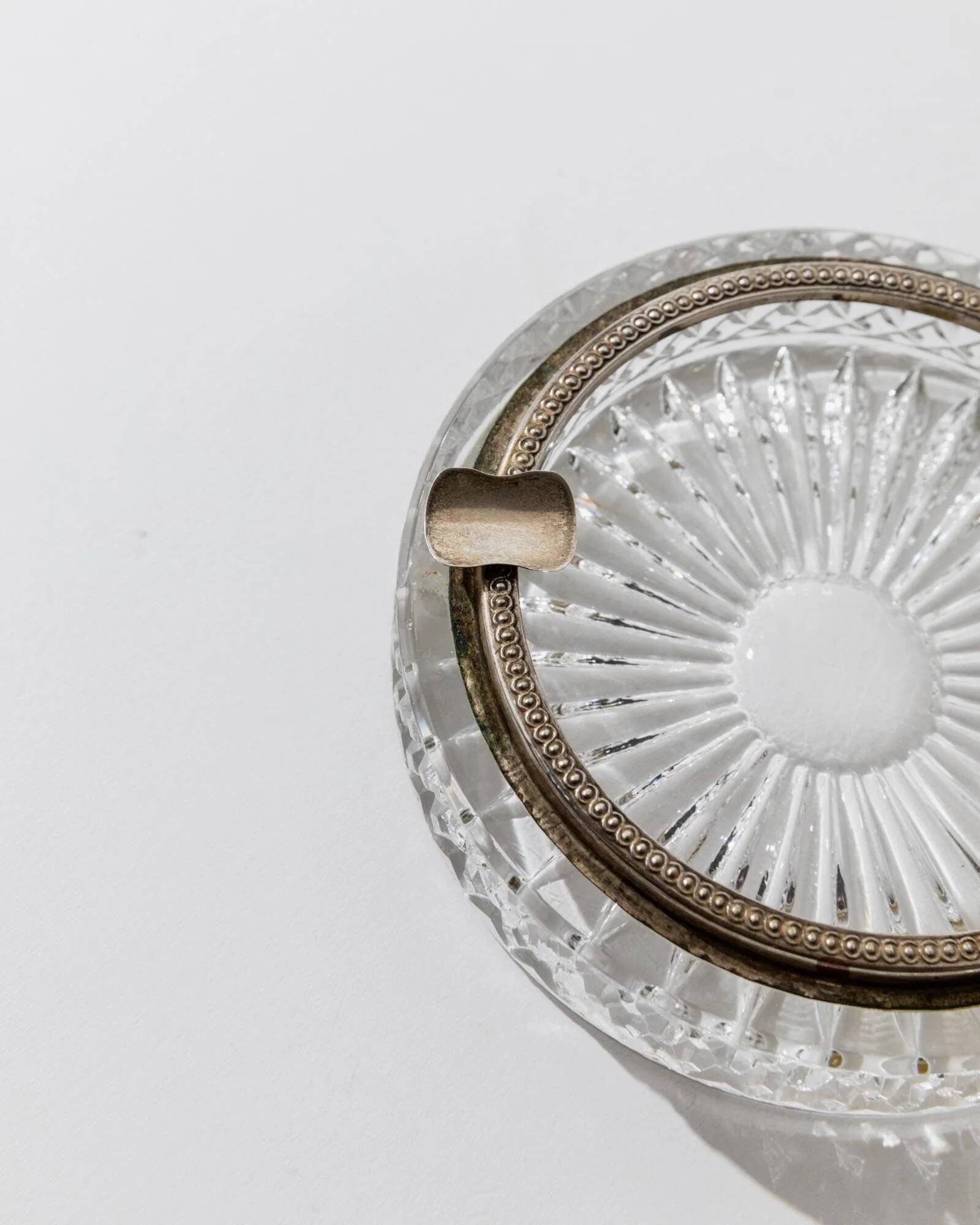Vintage crystal glass ashtray from the 1920s, silver-edged with a textured pattern, Art Deco table decoration.