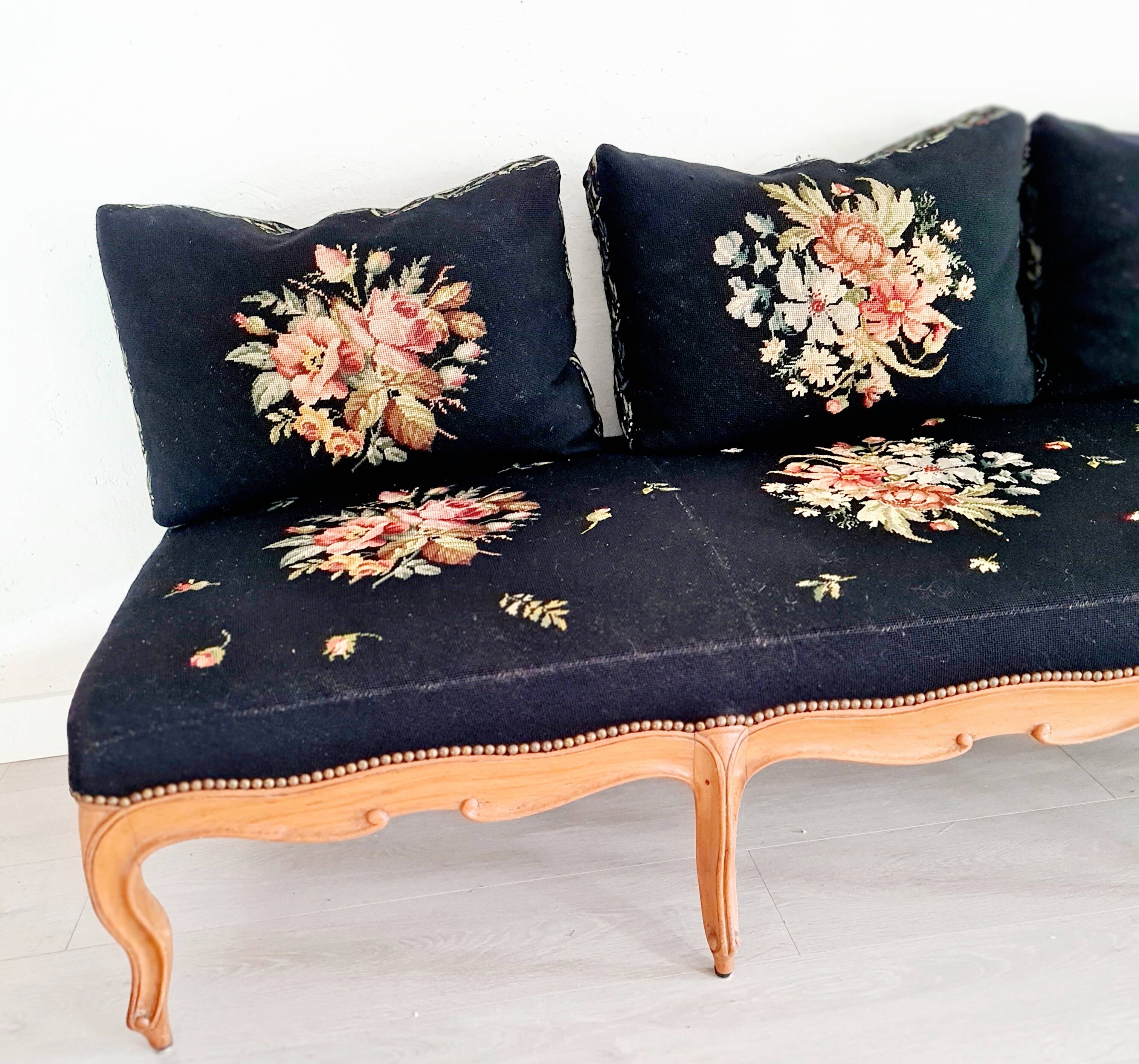 Old bench upholstered in black canvas flowers