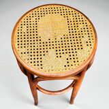 Old high stool in curved wood with caned seat