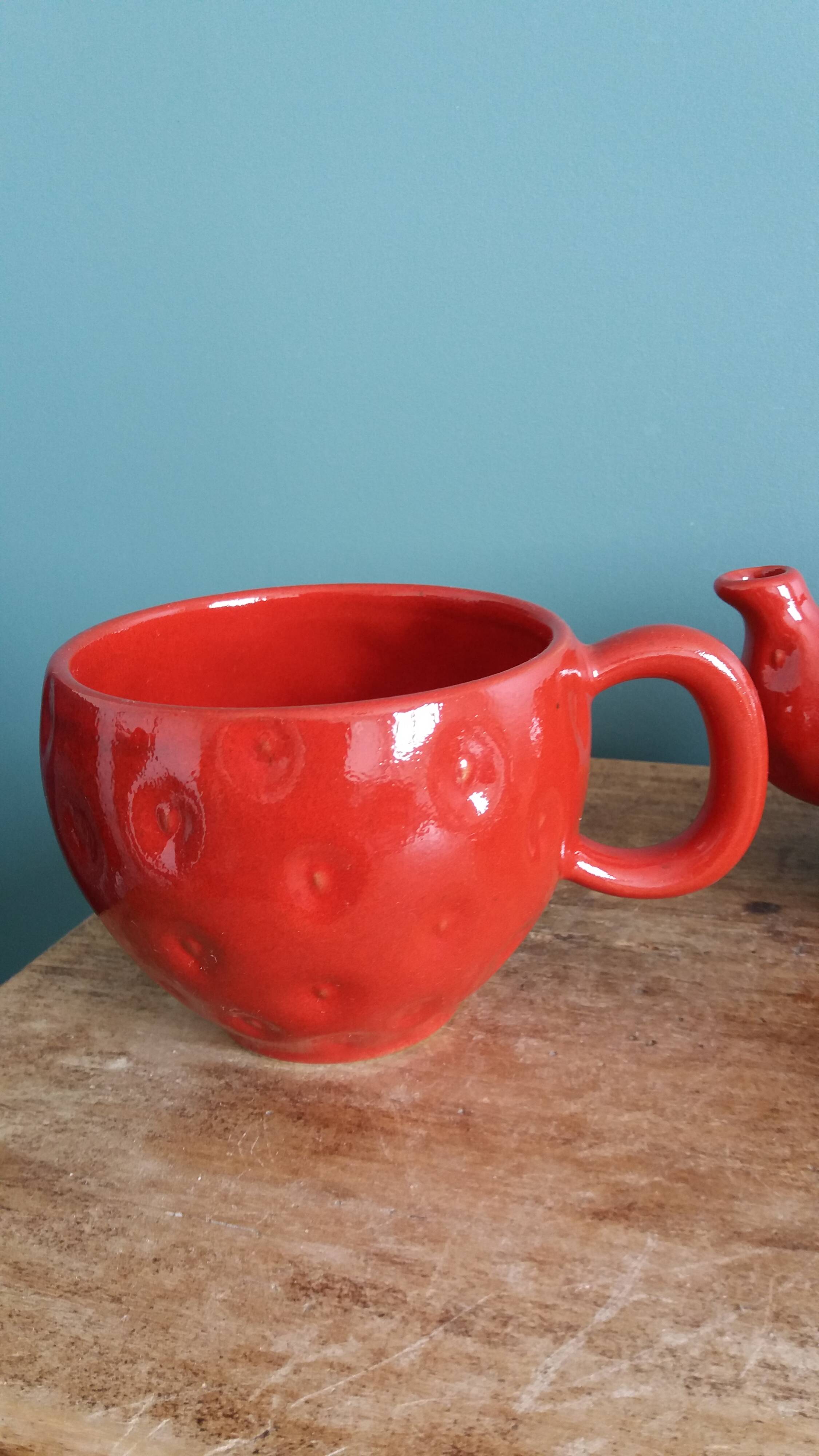 Teapot and cup in the shape of a strawberry.