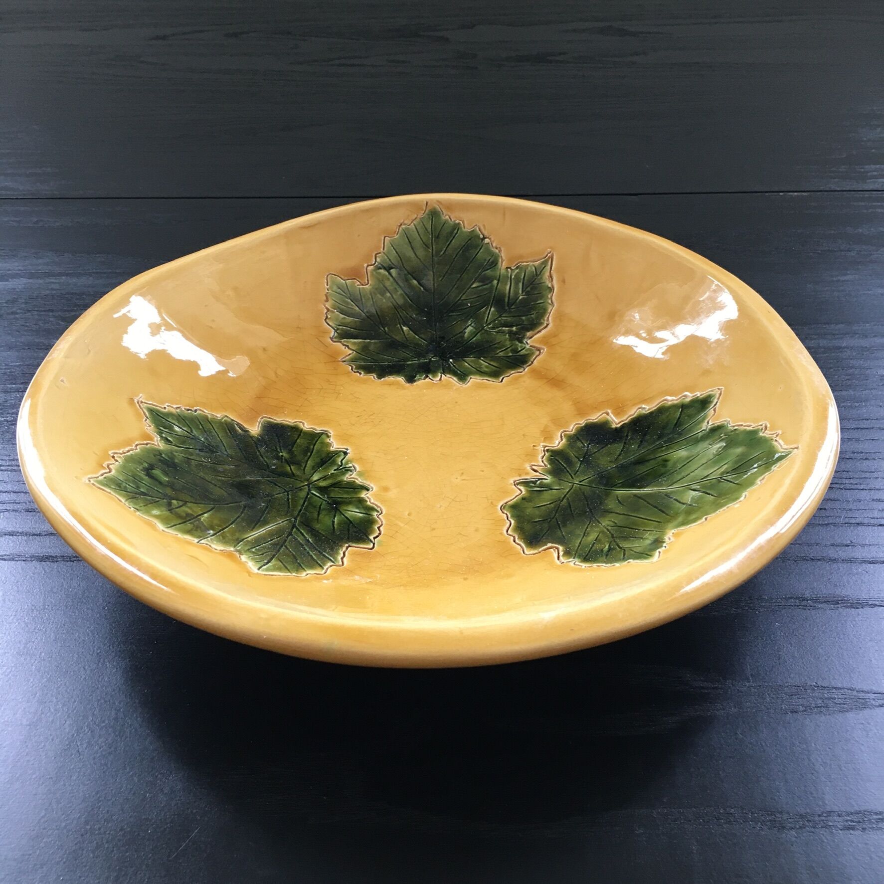 Plate signed with green leaf decoration.