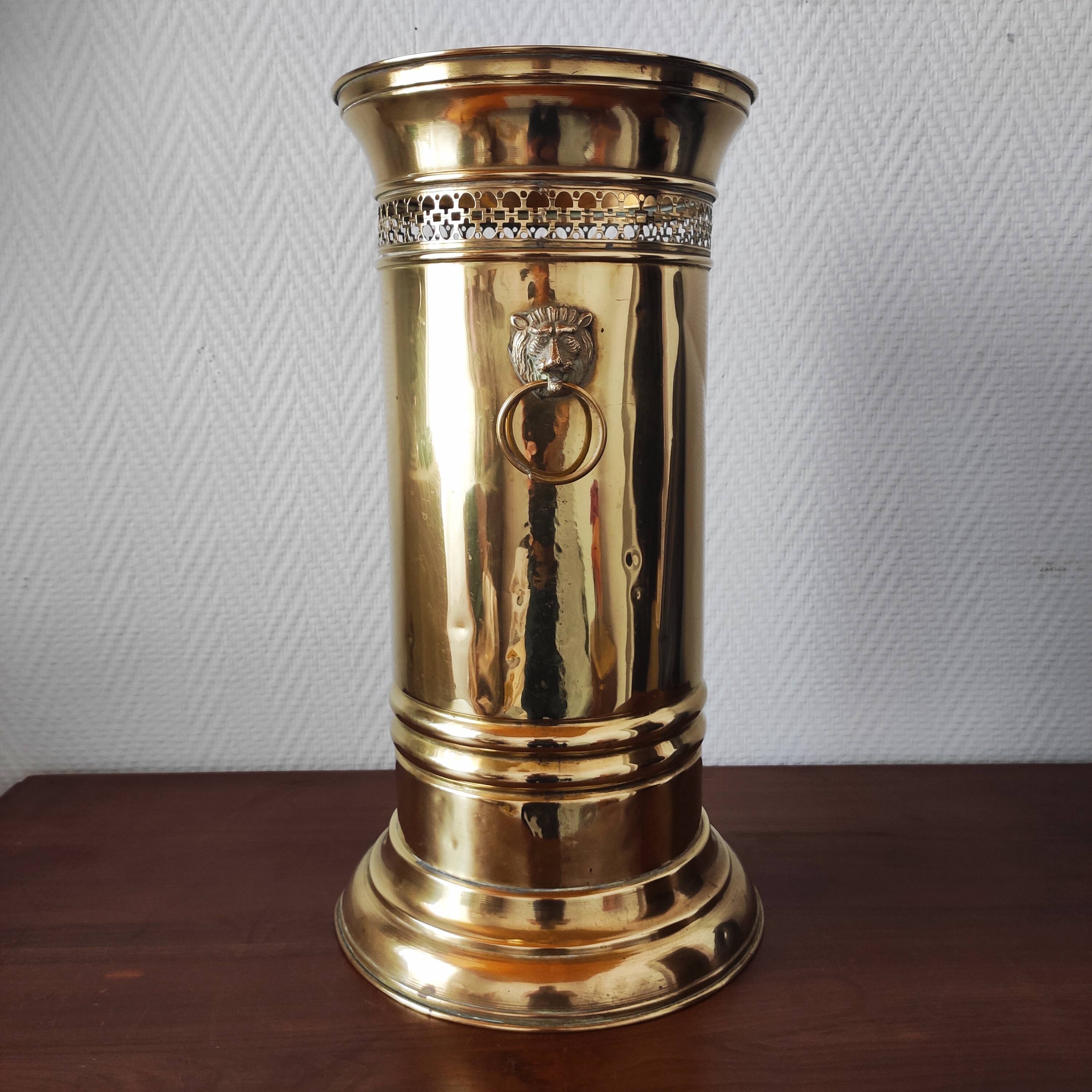 Vintage brass umbrella stand with lion decoration.