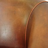 Neat, elegantly finished, cozy sheepskin club armchair with a fixed seat cushion