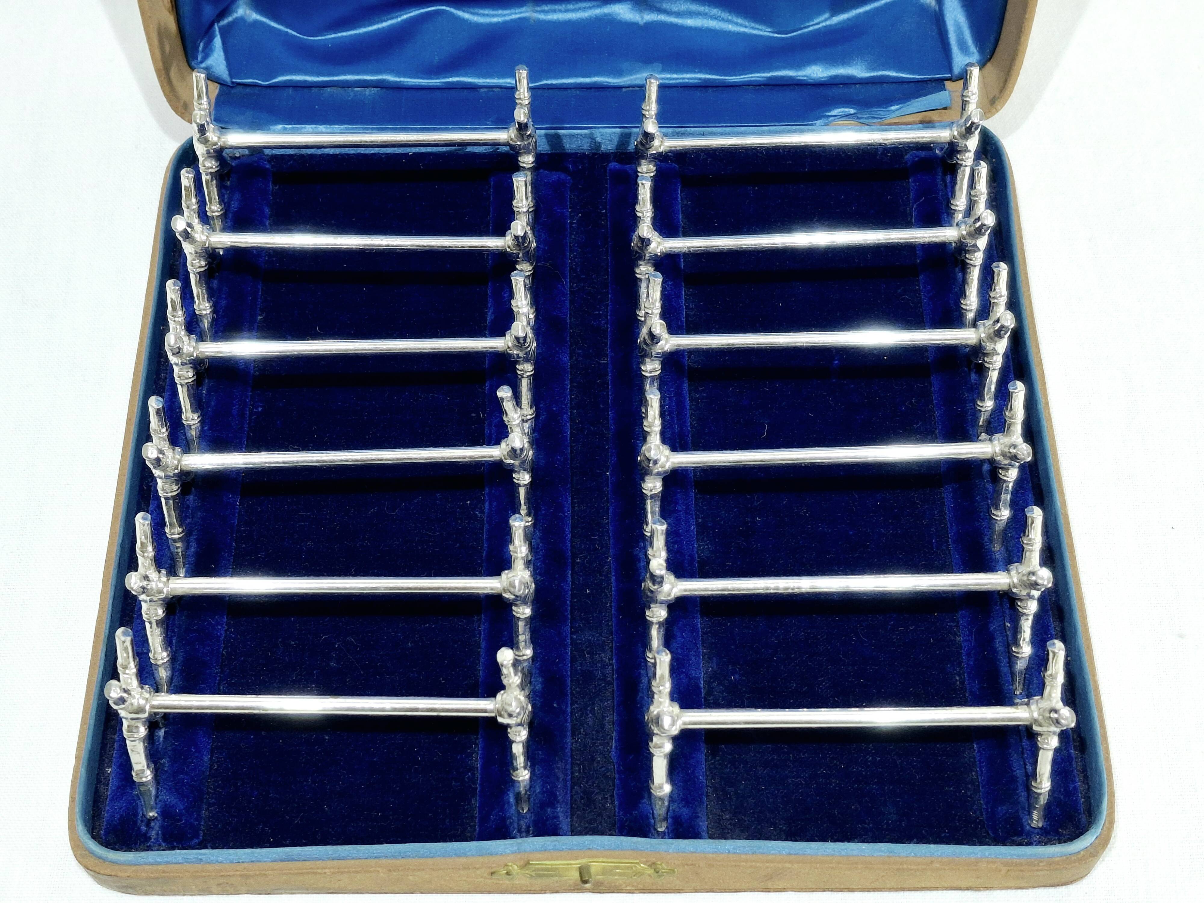 12 silver-plated metal knife handles, in a case.