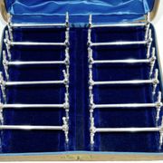 12 silver-plated metal knife handles, in a case.