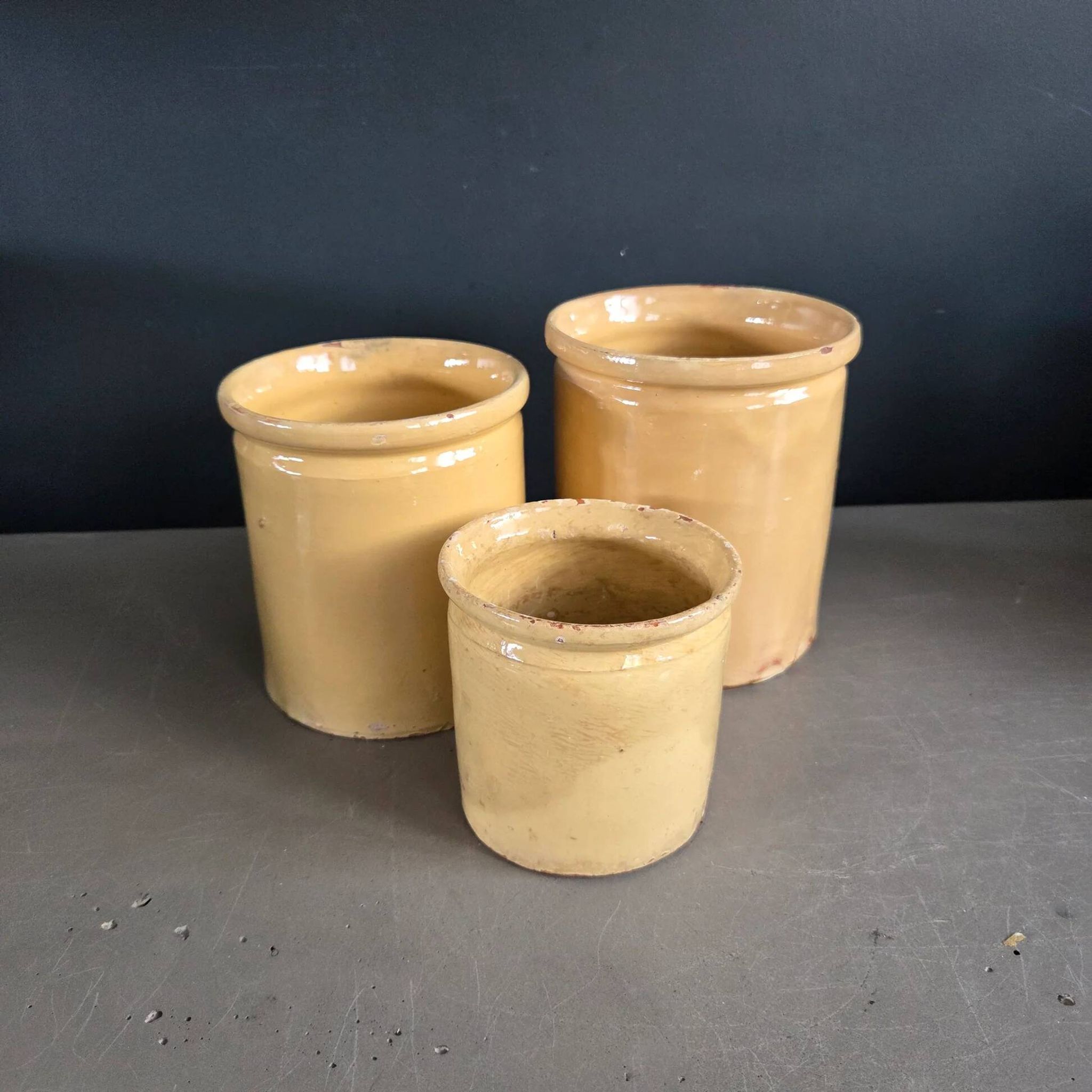 Trio of ancient pots in yellow glazed terracotta.
