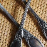 A set of 6 silver-plated metal soup spoons with foliage design.