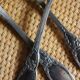 A set of 6 silver-plated metal soup spoons with foliage design.