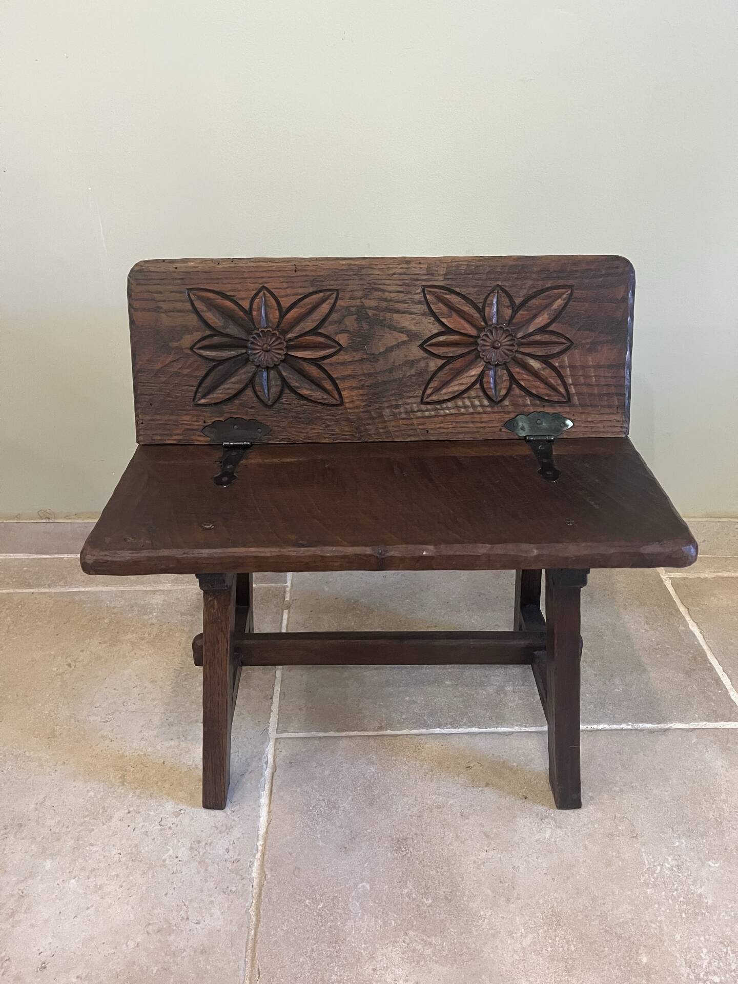 Small antique wooden bench with a folding backrest.