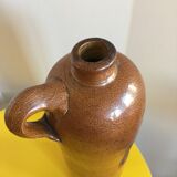 Old stoneware bottle with small handle and labels