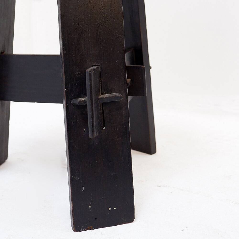 Vintage black-stained wooden tripod stool with mortise joints.