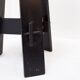 Vintage black-stained wooden tripod stool with mortise joints.