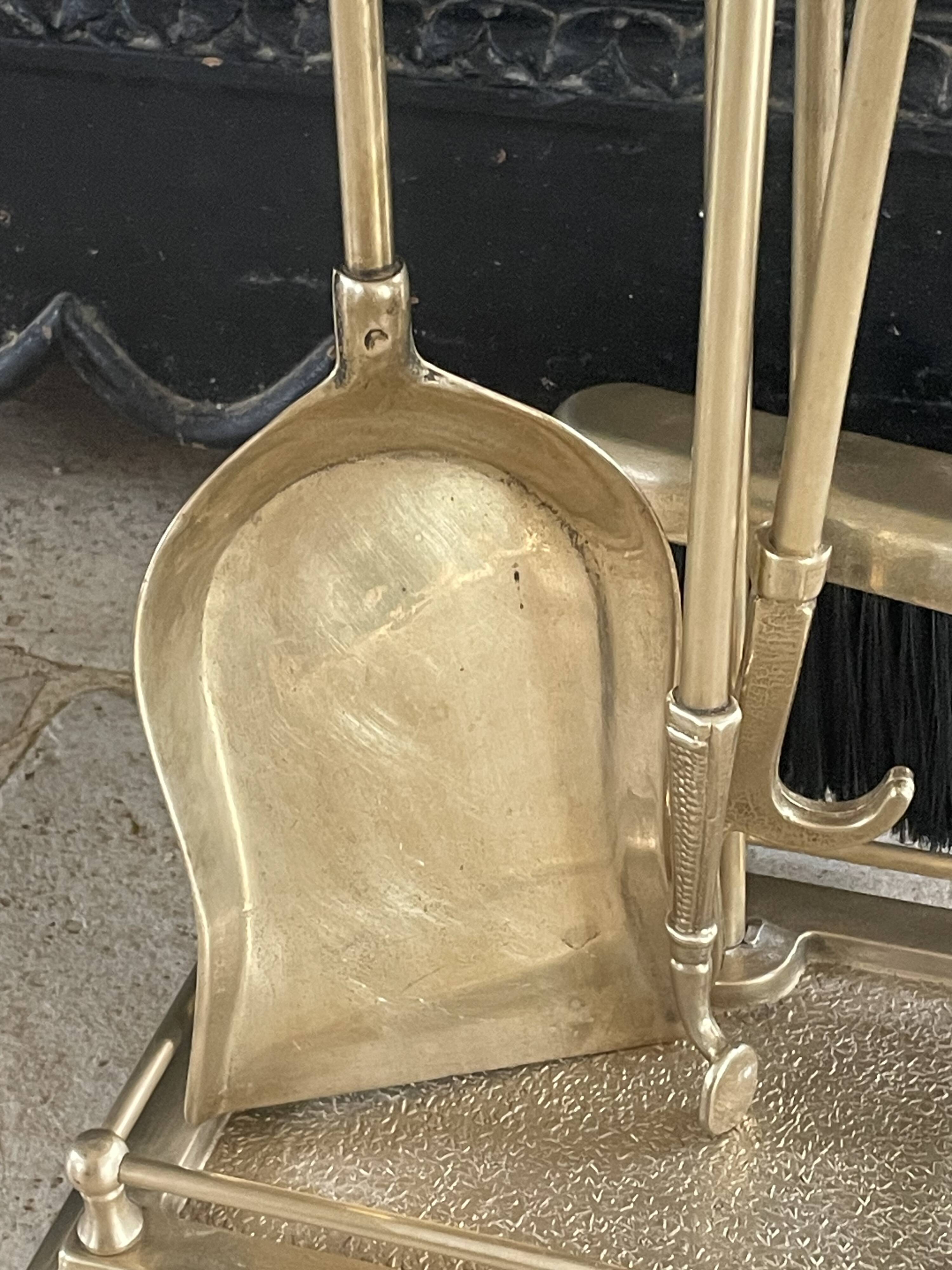 Brass fireplace tools in the style of Maison Baguès.