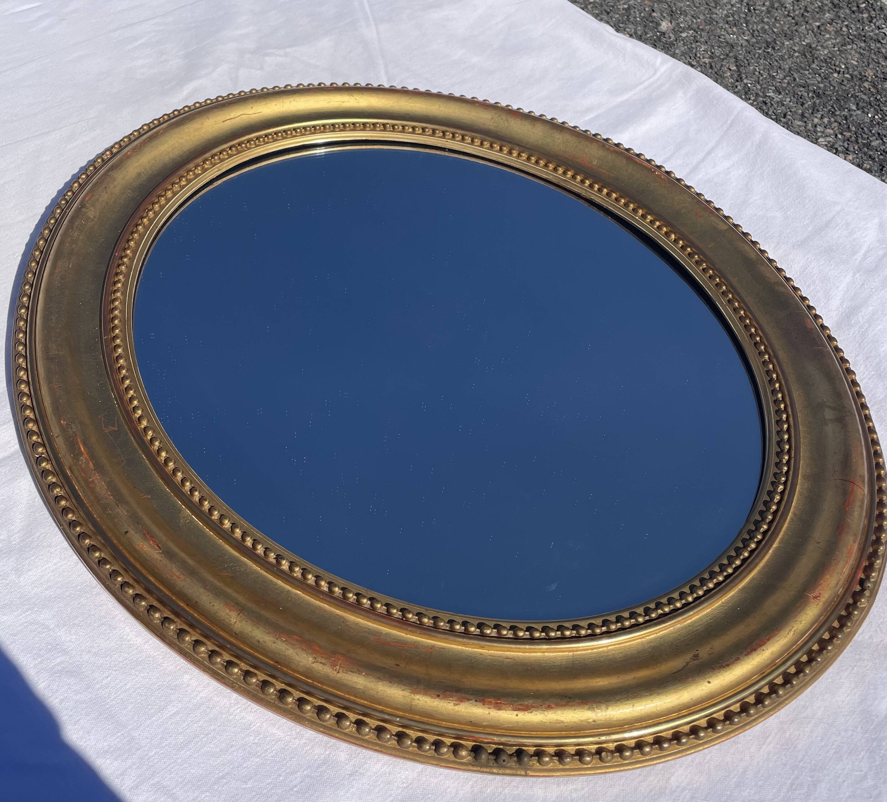 Duo de miroirs ovales et dorés en bois