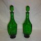 Set of 2 vintage green glass faceted carafes with stoppers.