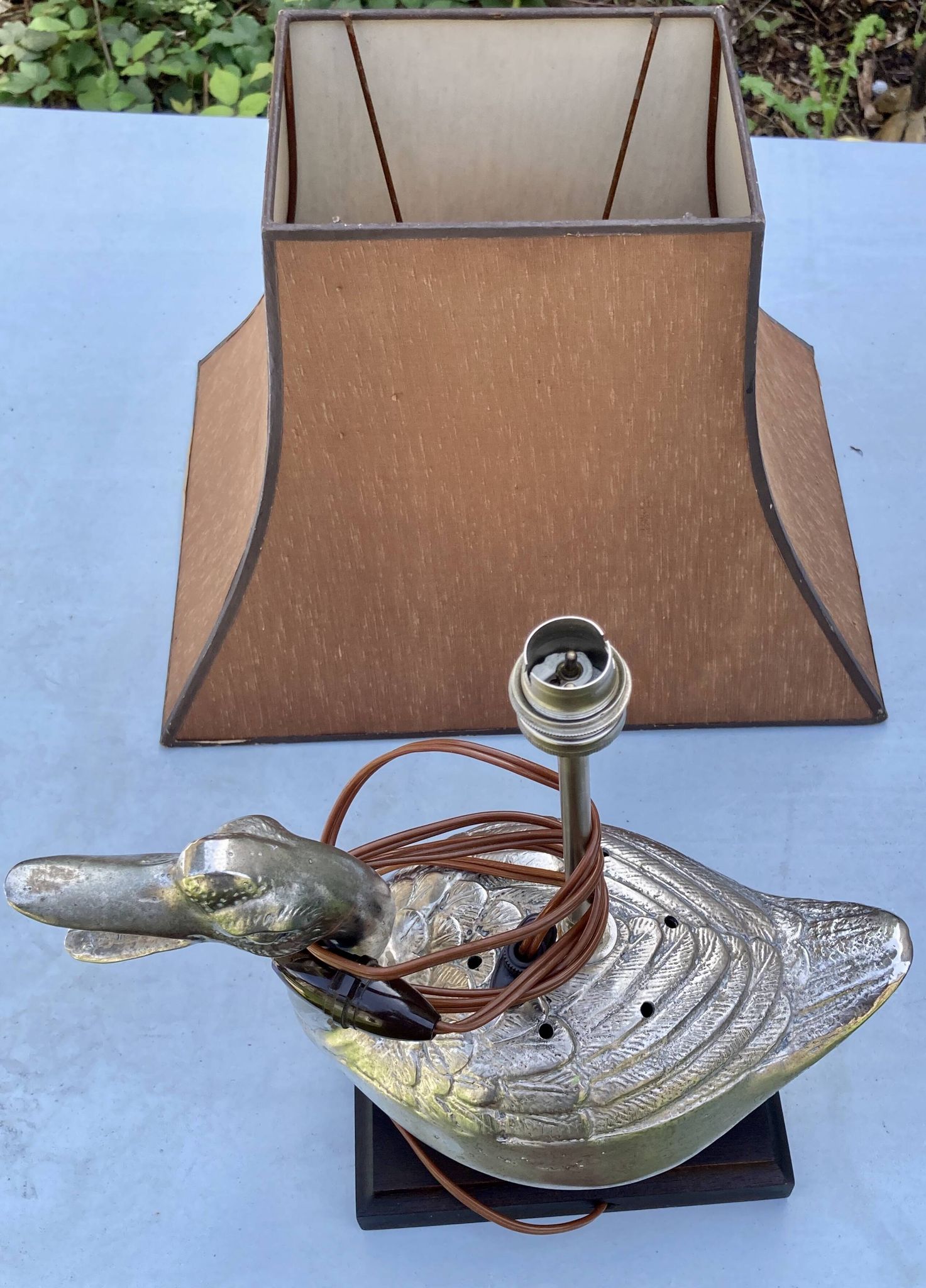 Old vintage lamp representing a duck in silver metal with wooden base