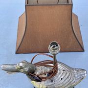 Old vintage lamp representing a duck in silver metal with wooden base