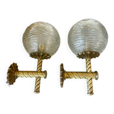 Pair of neoclassical wall sconces in twisted brass and ribbed glass.