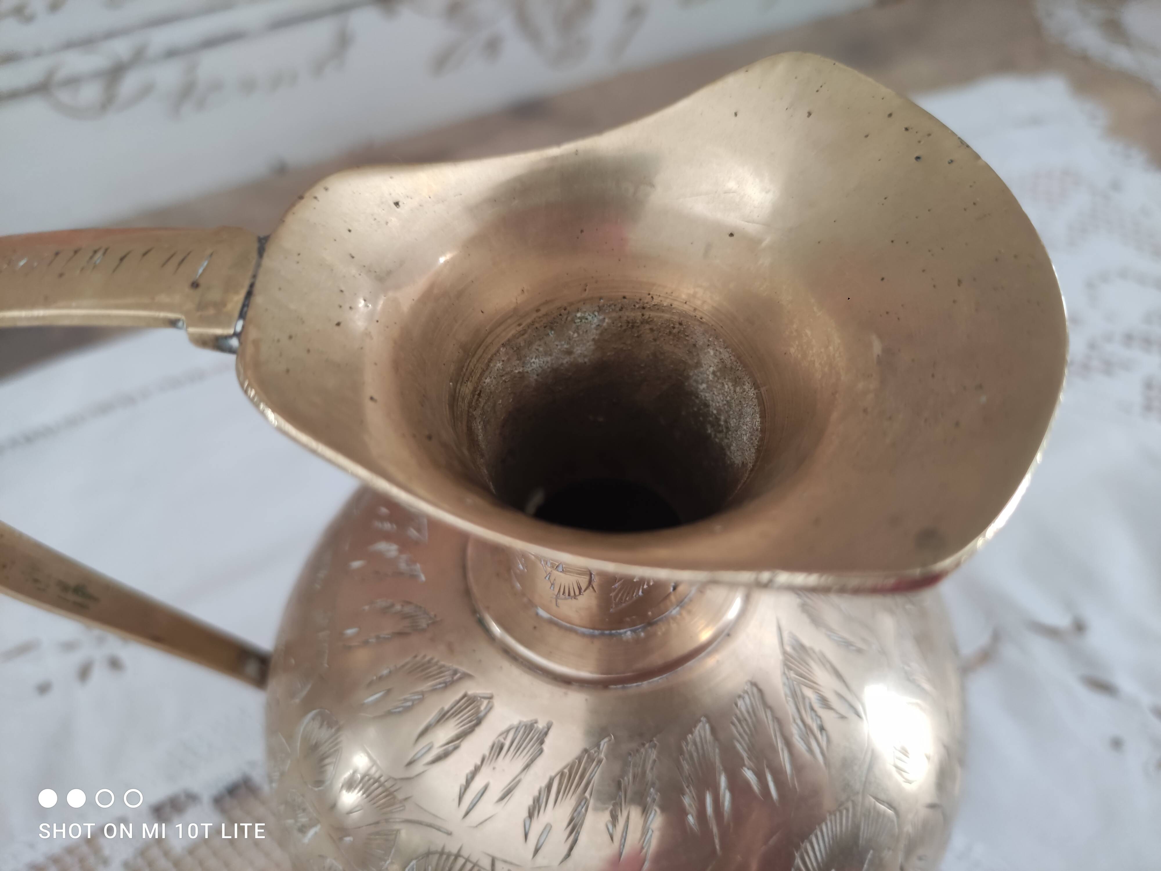 Chiseled brass pitcher decorated foliage