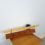 Vintage wall coat rack with black hooks and light wood