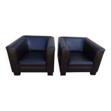 2 club armchairs with a chocolate faux leather seat and backrest and wooden legs.