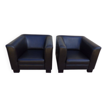 2 club armchairs with a chocolate faux leather seat and backrest and wooden legs.