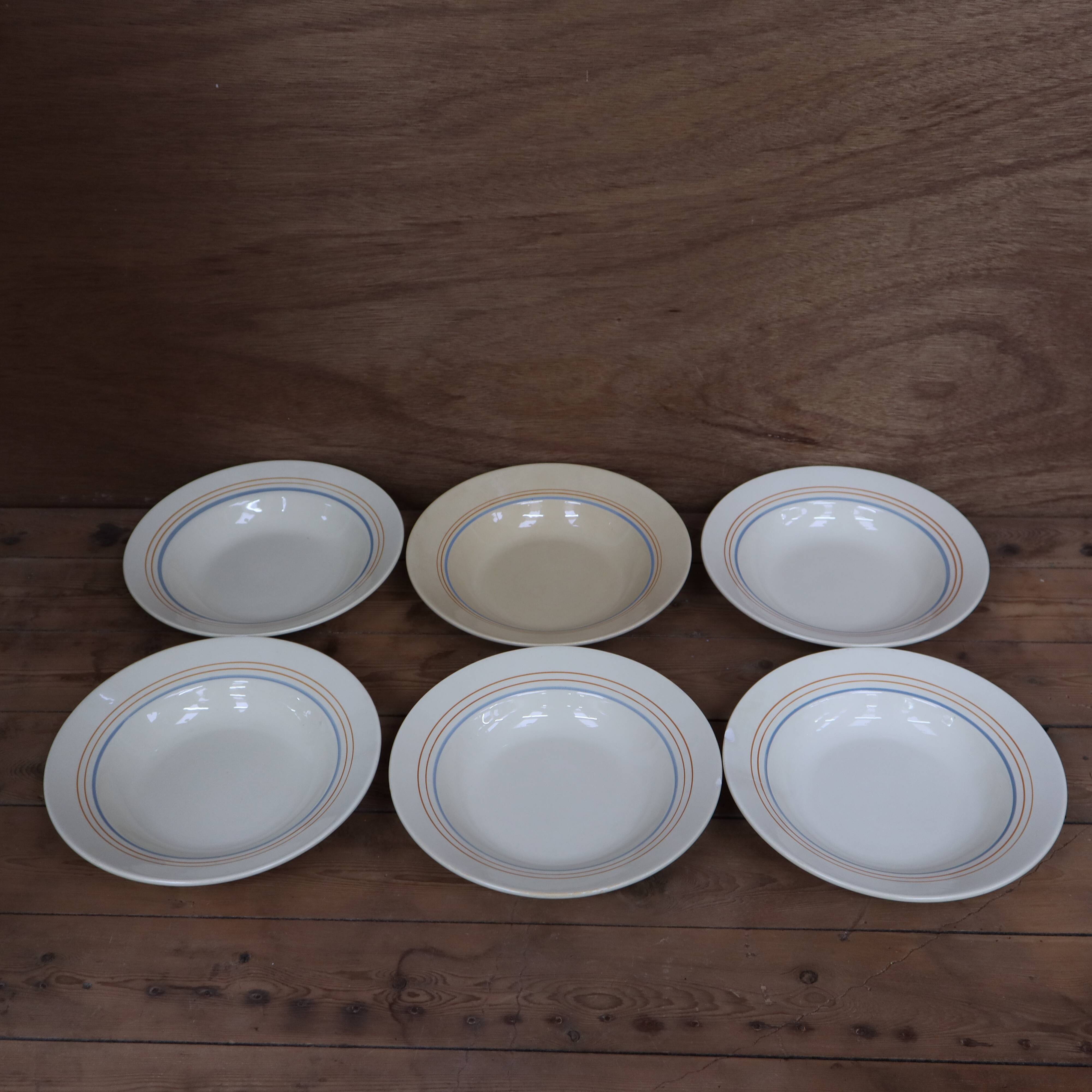 6 old cream-coloured deep plates with blue/orange trim.