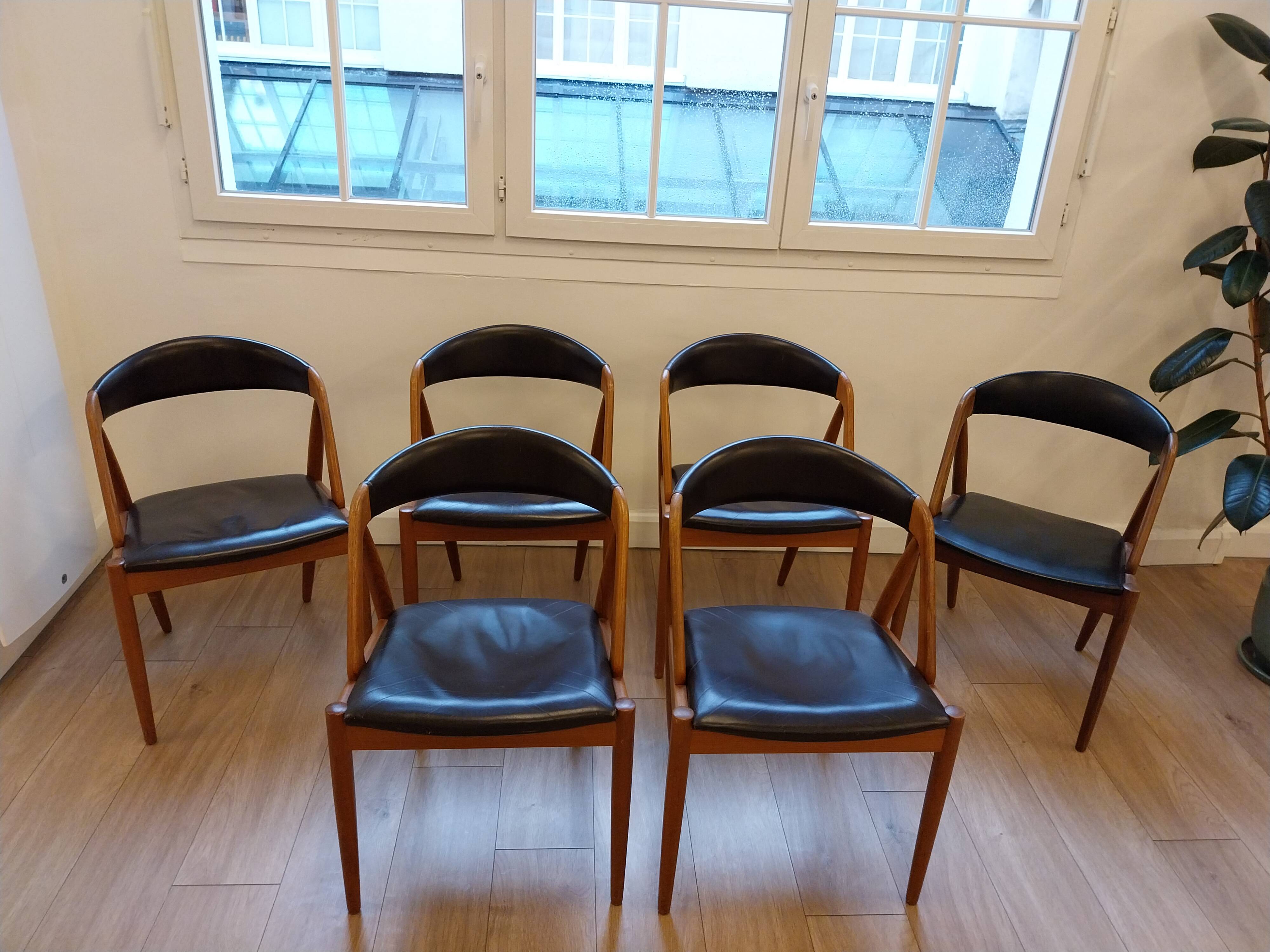 Set of 6 vintage Kai Kristiansen chairs in solid teak and black faux leather.