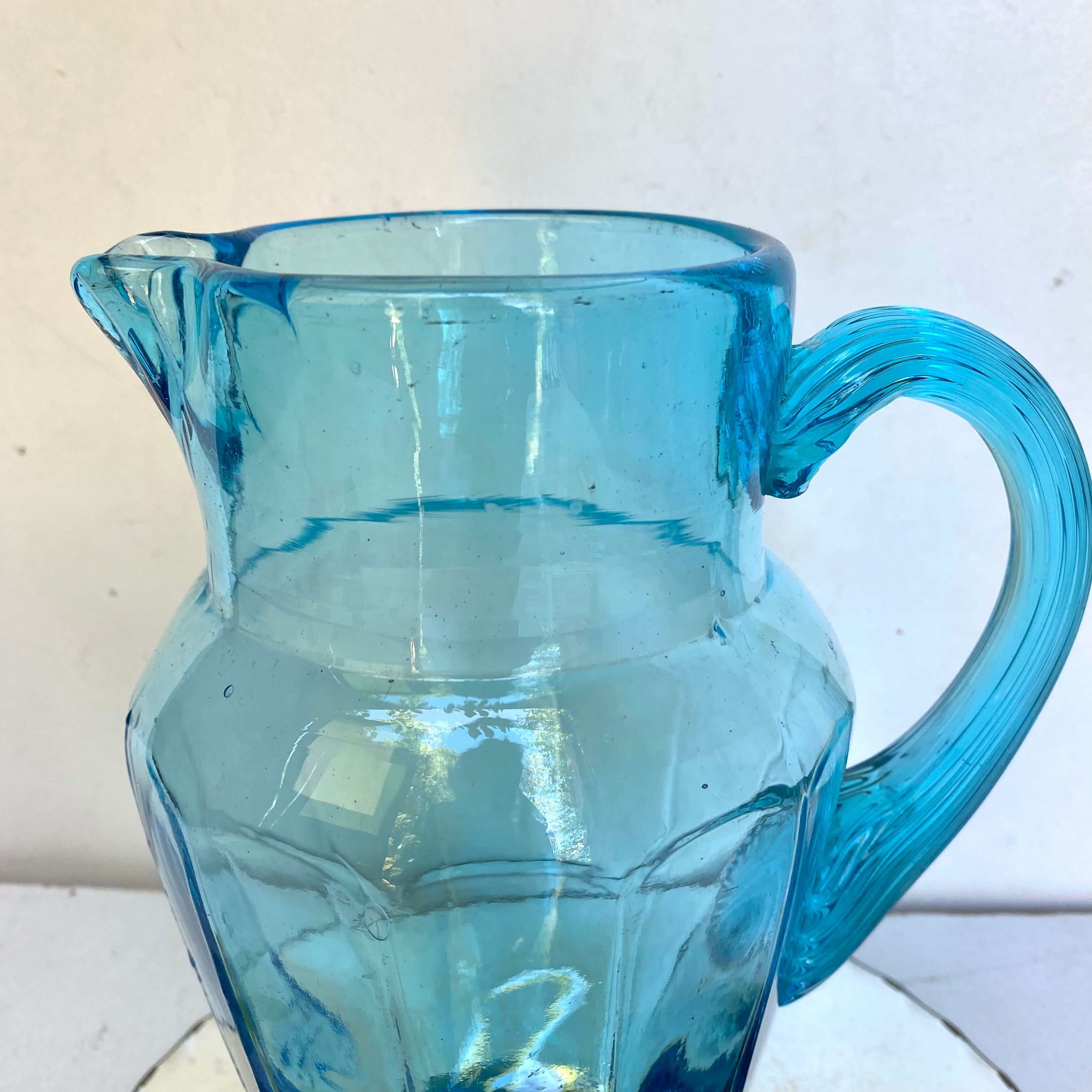 Old pitcher in blue glass