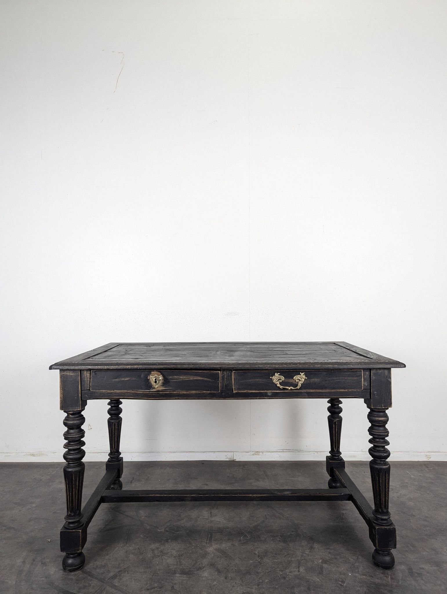 Louis XIII style desk in blackened wood with turned legs and two drawers.