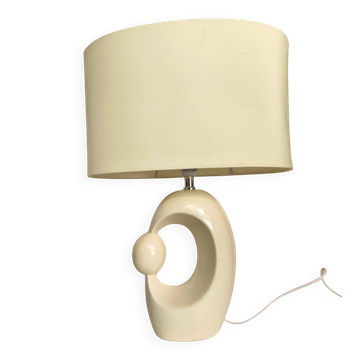 Cream ceramic table lamp with a mid-century design, featuring a lampshade.