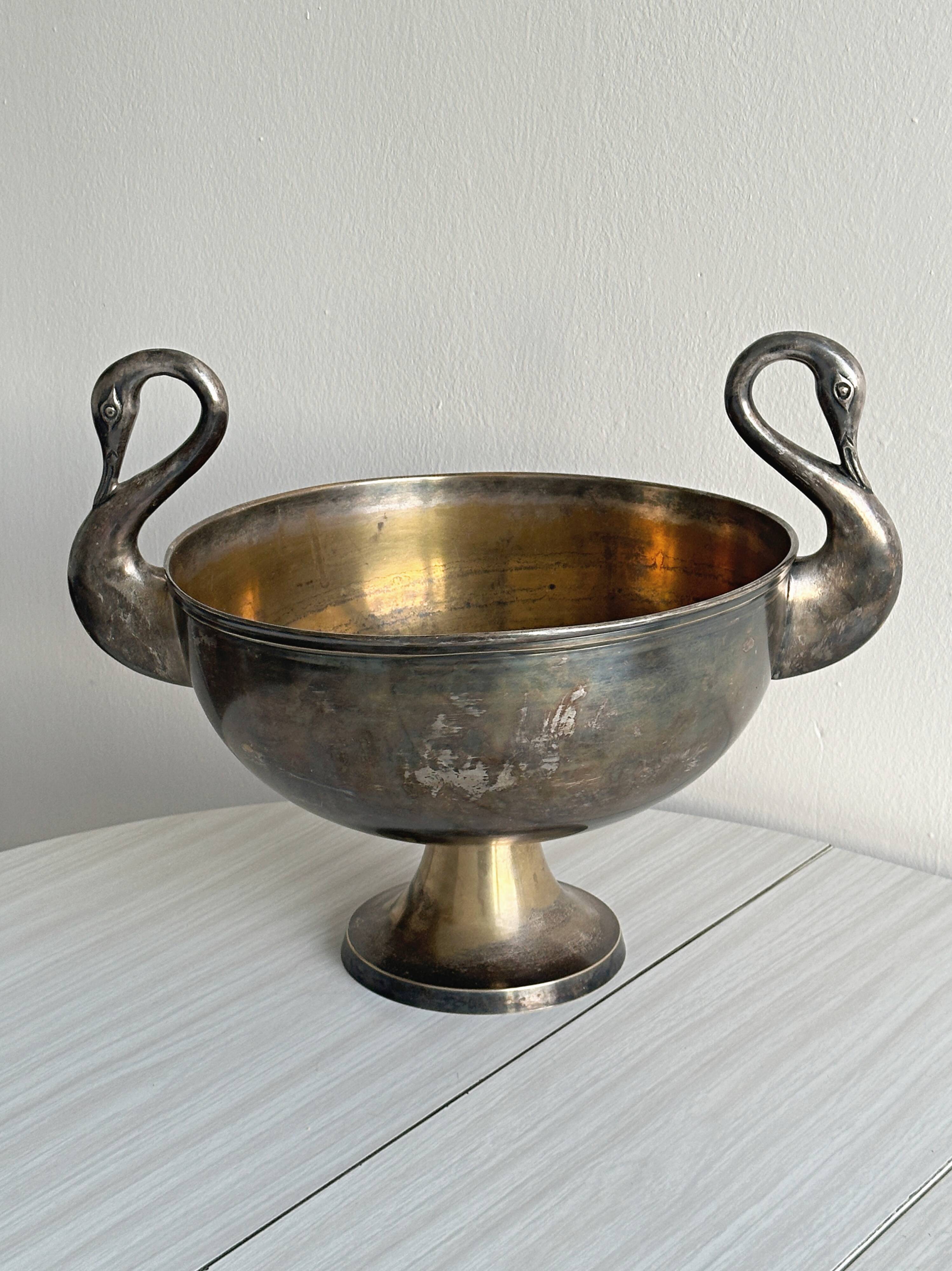 Large champagne bucket with patinated metal swan handles.