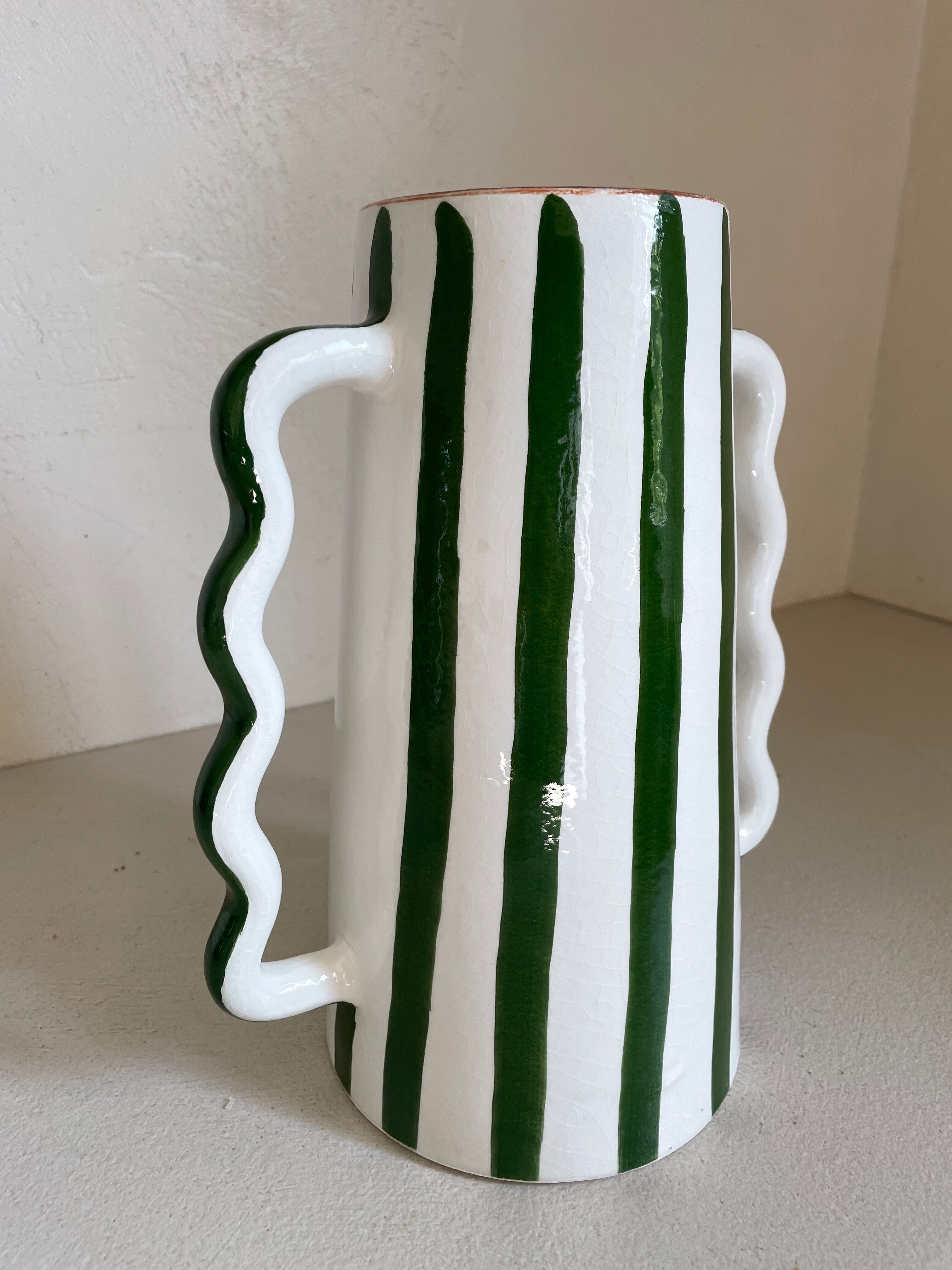 Green and white striped ceramic vase with abstract handmade corrugated handheld