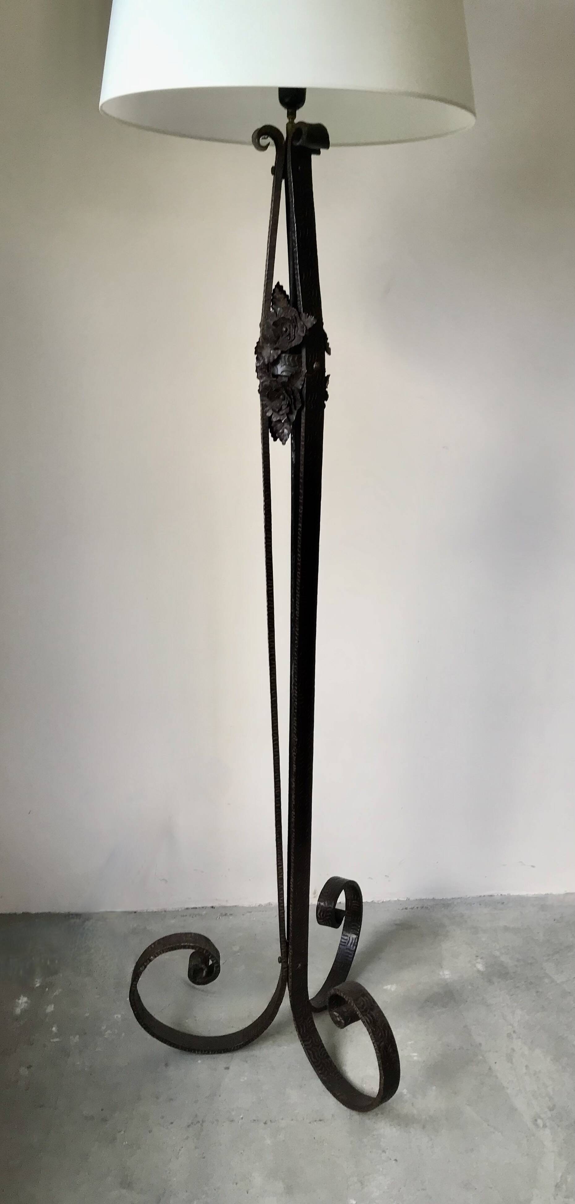 Art deco wrought iron floor lamp decorated with flowers, circa 1930.