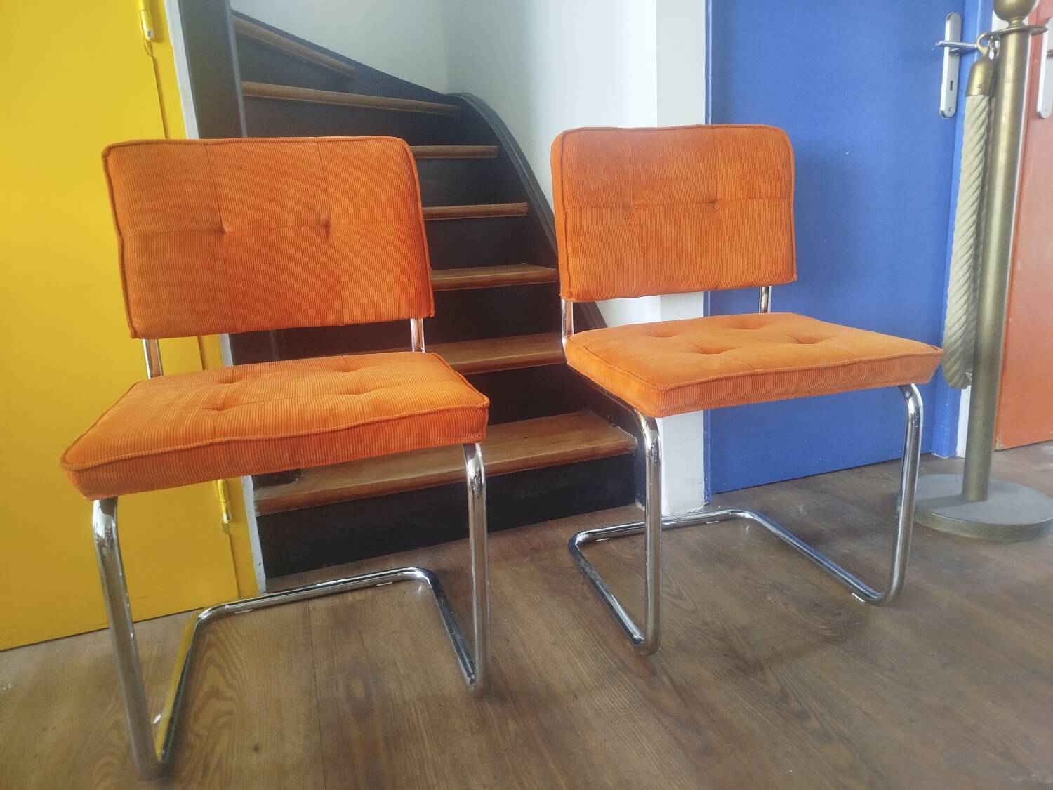Pair of vintage cantilever chairs in chrome and orange corduroy.