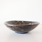 Empty pocket in fossilized black marble