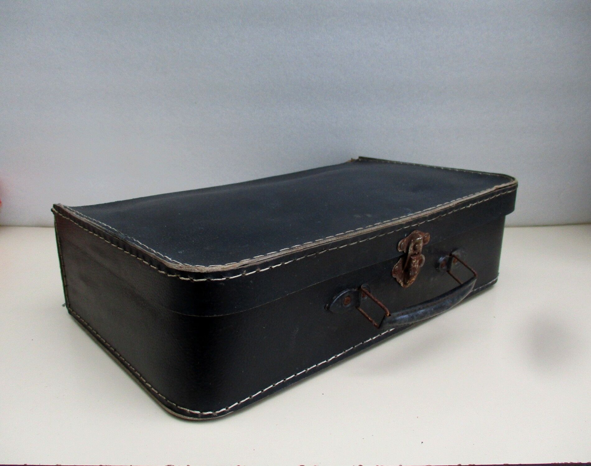 Small suitcase in old navy blue cardboard