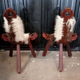Pair of brutalist tripod chairs in wood and cowhide