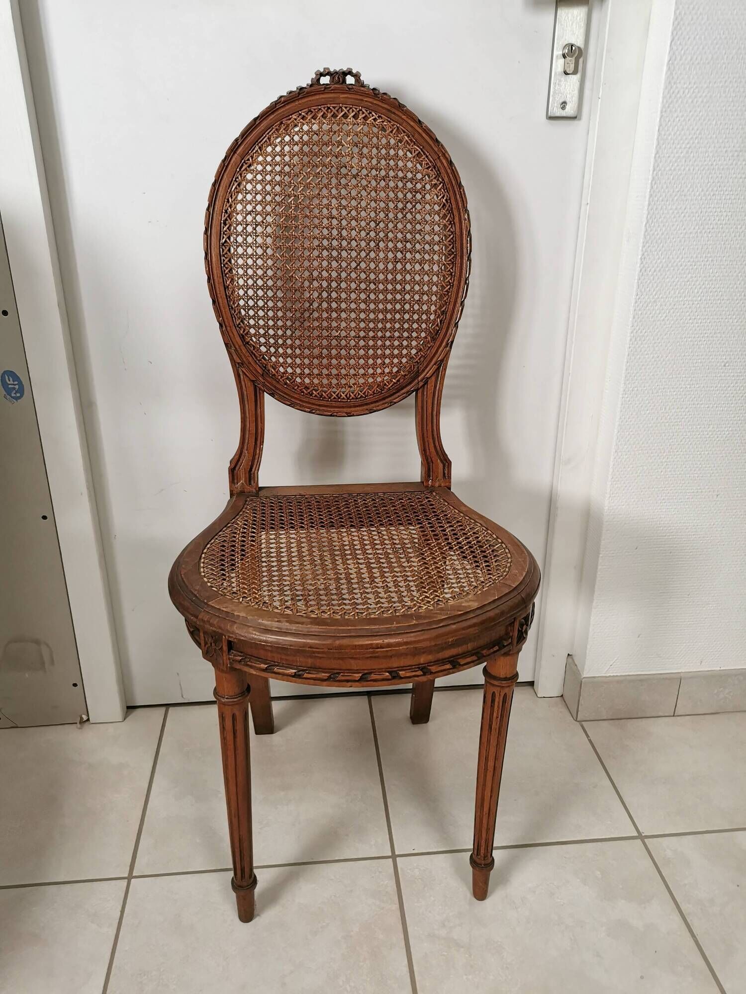 Antique chair Louis XVI style, seat caned, carved wood