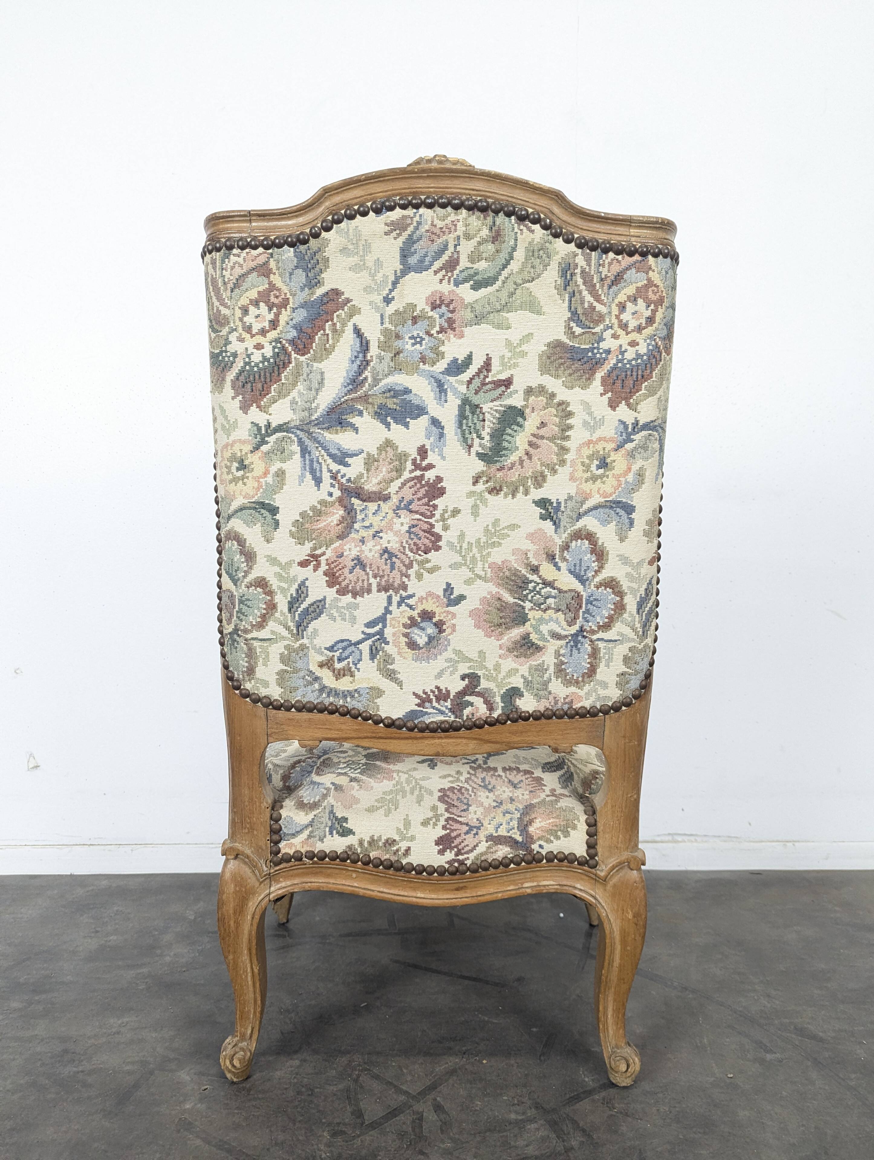 Louis XV style armchair in natural wood with floral fabric.