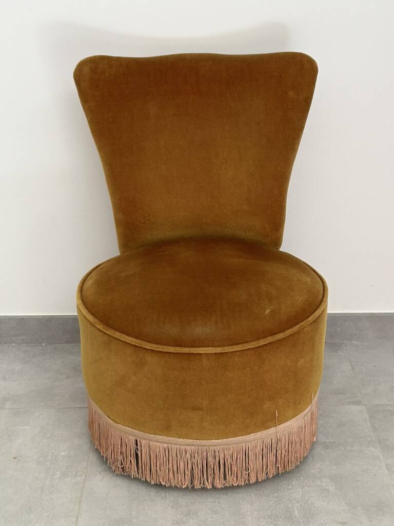 Ochre and fringed pouffe-style armchair