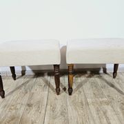 A pair of English upholstered pouffes/footstools from the 19th century