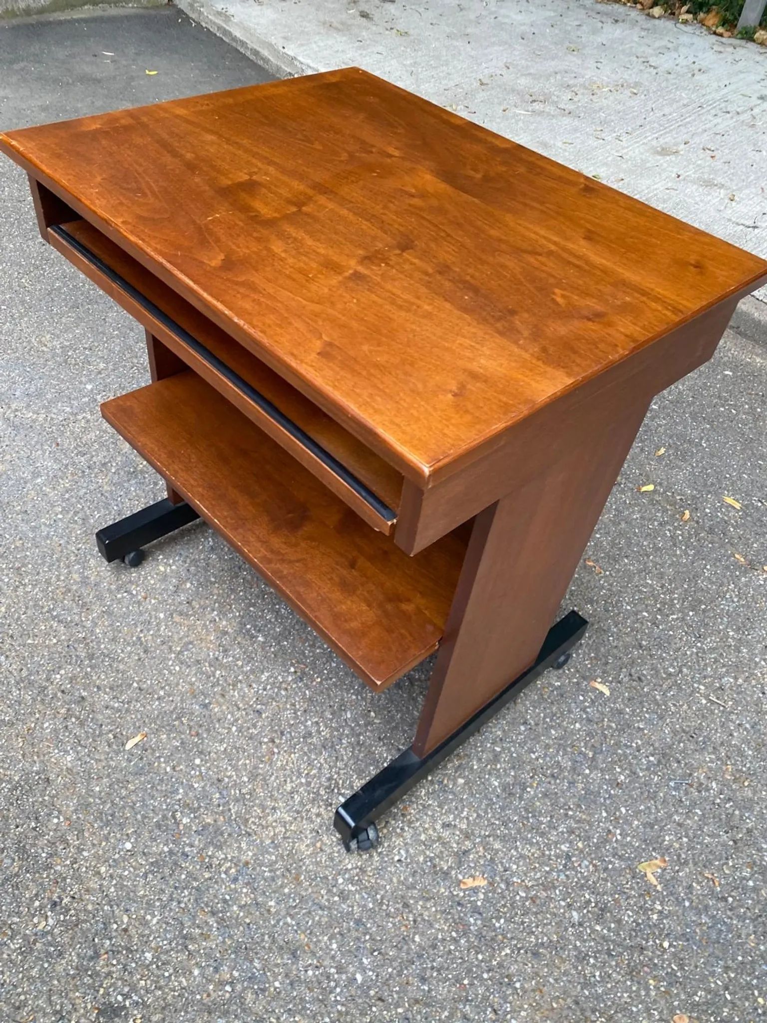 Small Scandinavian-style computer desk on wheels made of wood.