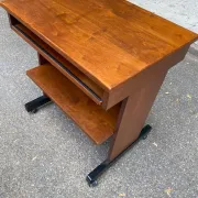 Small Scandinavian-style computer desk on wheels made of wood.