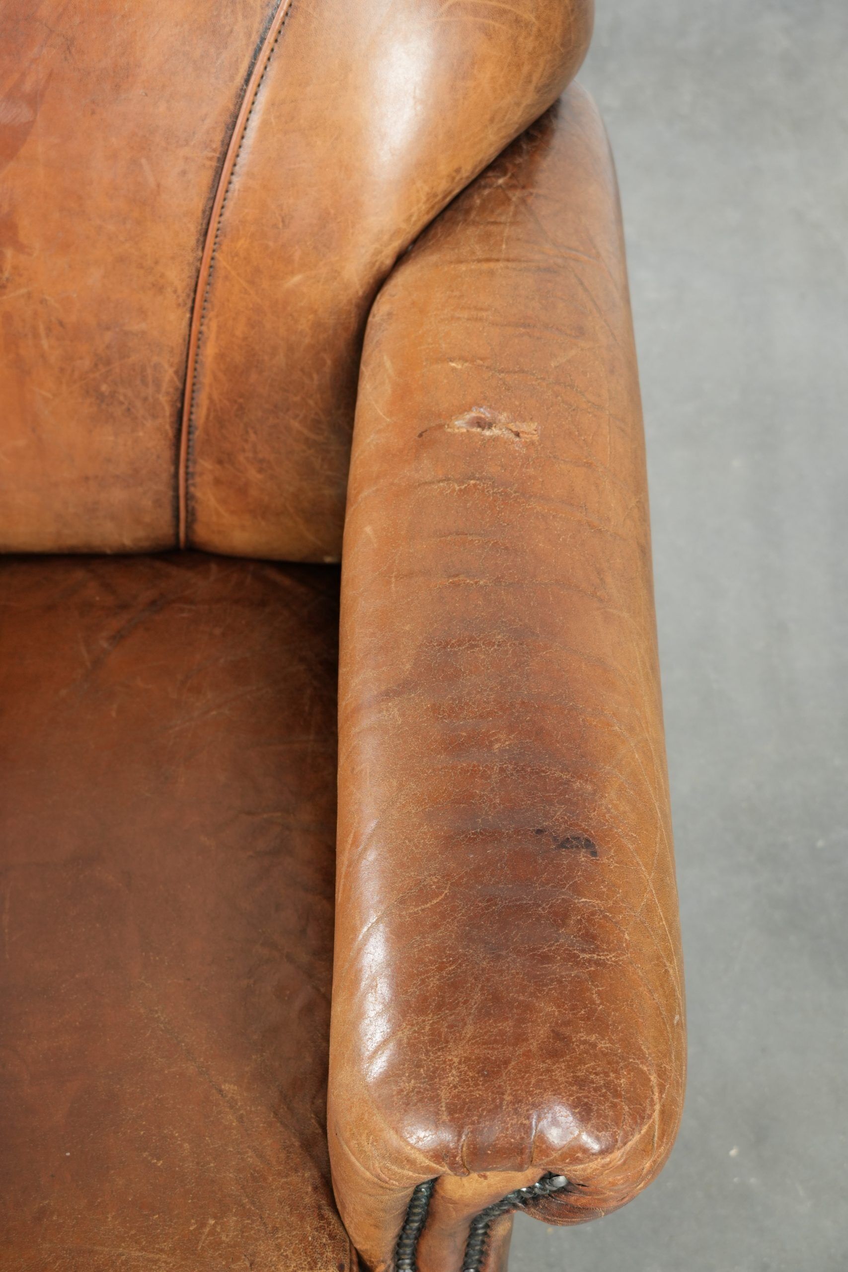 Sheepskin armchair with a beautiful vintage look and decorative nail finish
