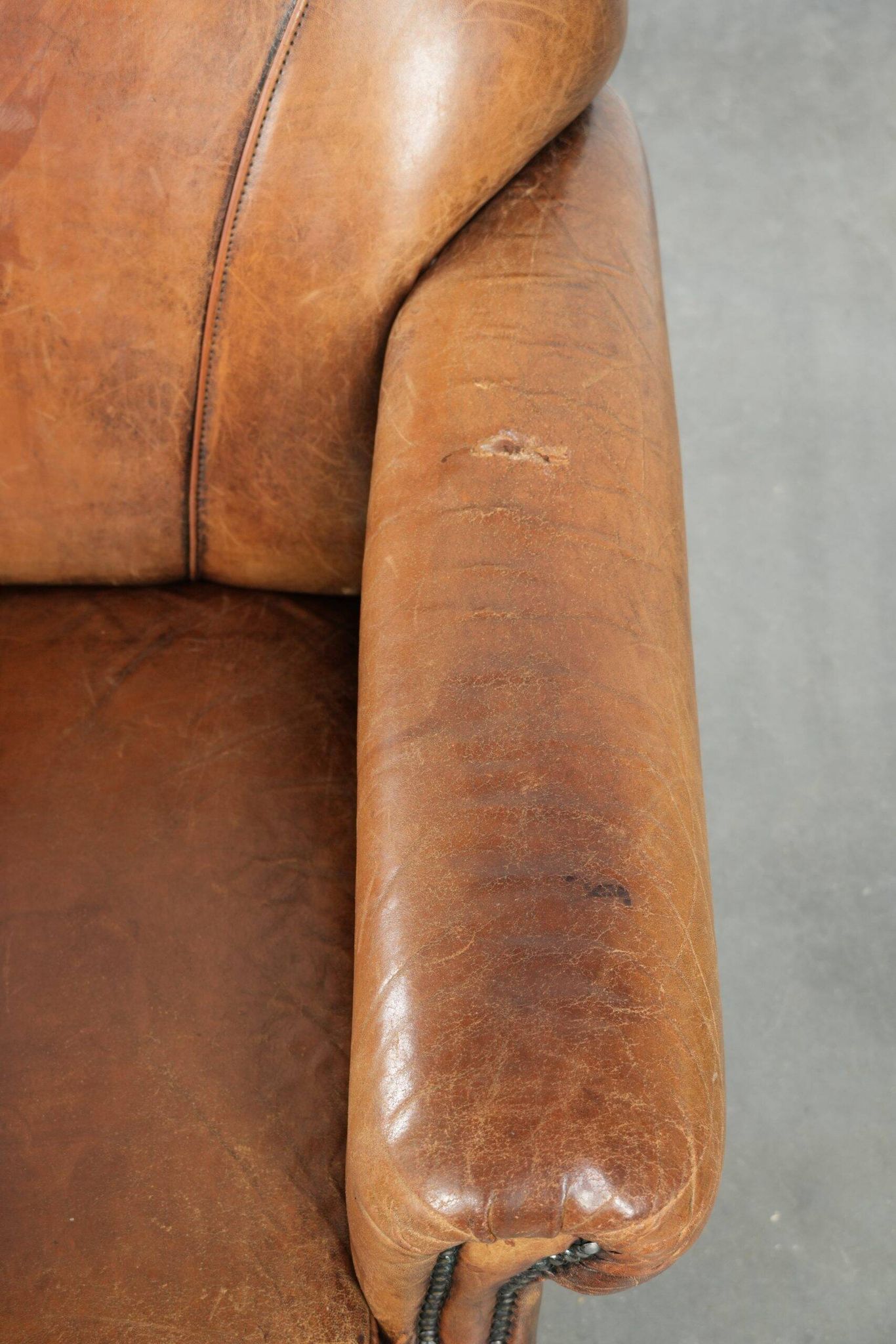 Sheepskin armchair with a beautiful vintage look and decorative nail finish
