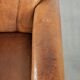 Sheepskin armchair with a beautiful vintage look and decorative nail finish