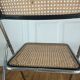 Vintage folding chair in metal and cane.