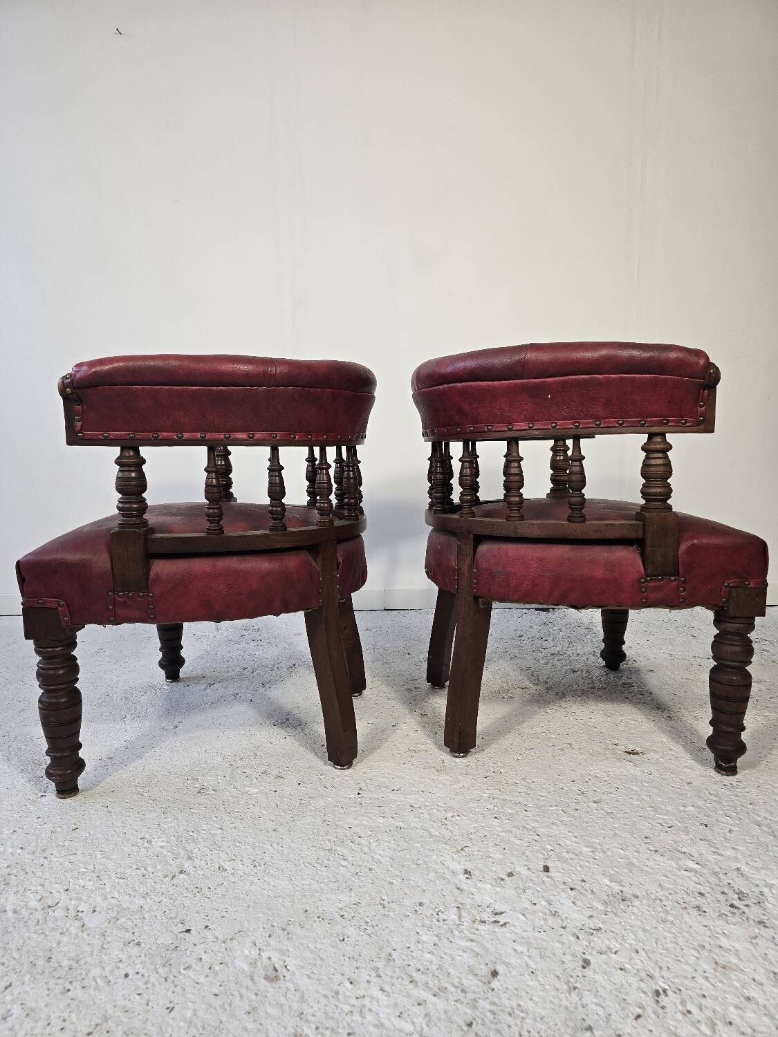 Pair of barrel chairs in turned wood and burgundy leather – Productio